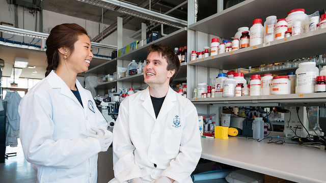 Two students smiling in a biomedical engineering lab at BME