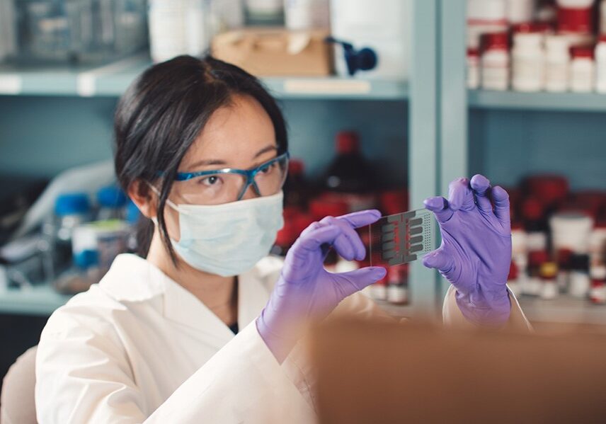 Betty Li holding up a microfluidic device